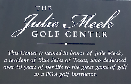 Photo of plaque located on the golf shack. Title is The Julie Meek Golf Center. This Center is named in honor of Julie Meek, a resident of Blue Skies of Texas, who dedicated over fifty years of her life to the great game of golf as a PGA golf instructor.