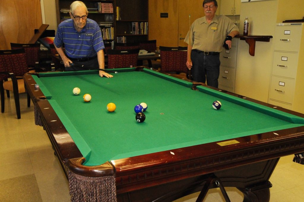 Photo of Blue Skies of Texas billiard room showing two members at a pool table.